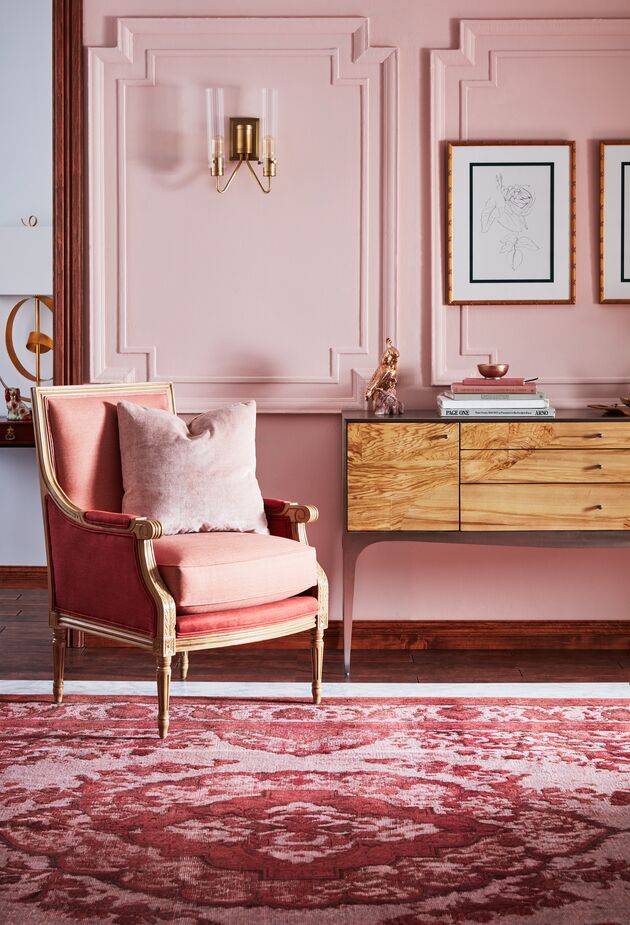 The console table is sleekly modern in design, but the soft pink and corals of the walls, the James Accent Chair, and the rug hark back to an earlier time. Photo by Cheng Lin.
